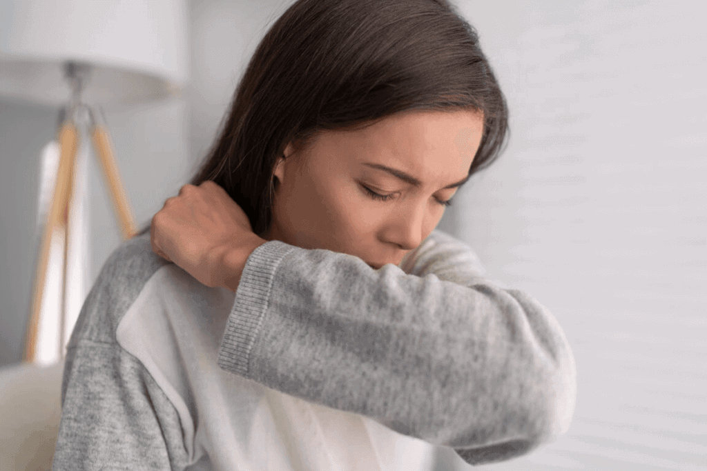 woman coughing into her elbow