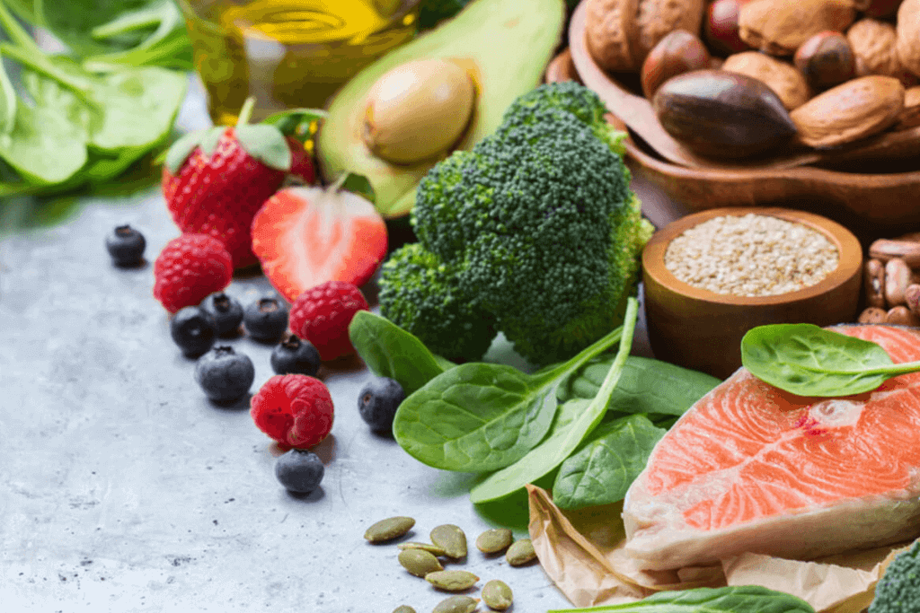variety of foods including raw fish, broccoli, strawberries, nuts, and oil