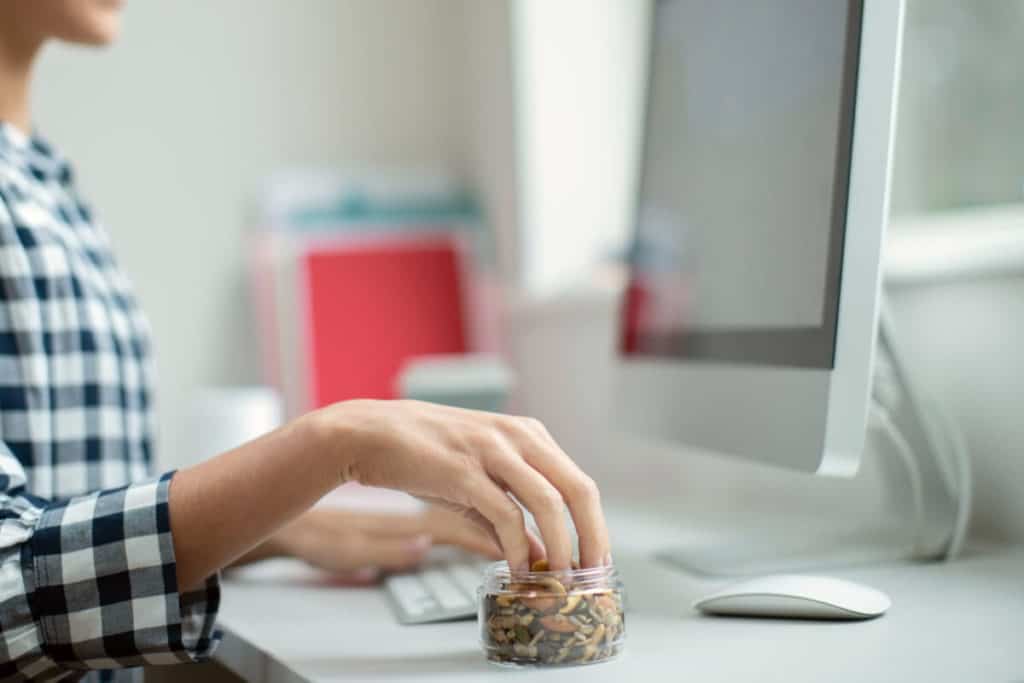 Man sitting at desk eating sunflower seeds