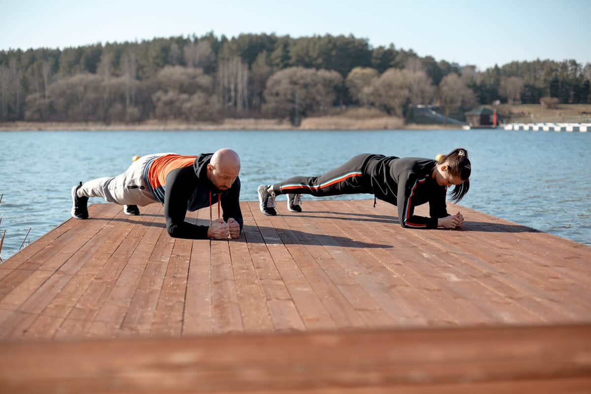 Two people planking on a dock