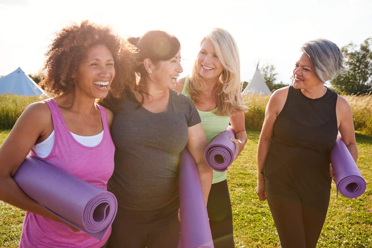 Woman carrying yoga mats laughing