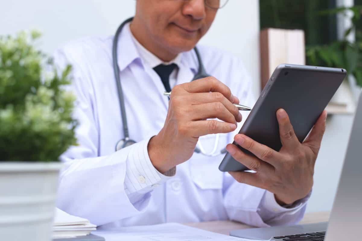 Doctor using an EHR patient platform on a smart tablet