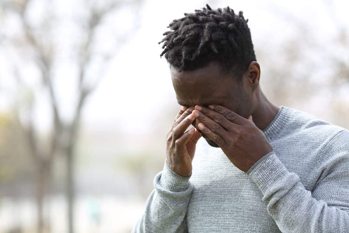 Mold exposure man rubbing eyes 