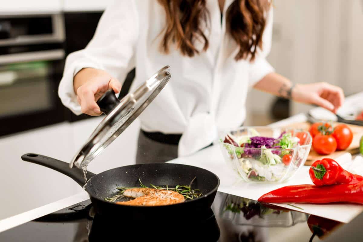 Woman cooking food on a frying pan 