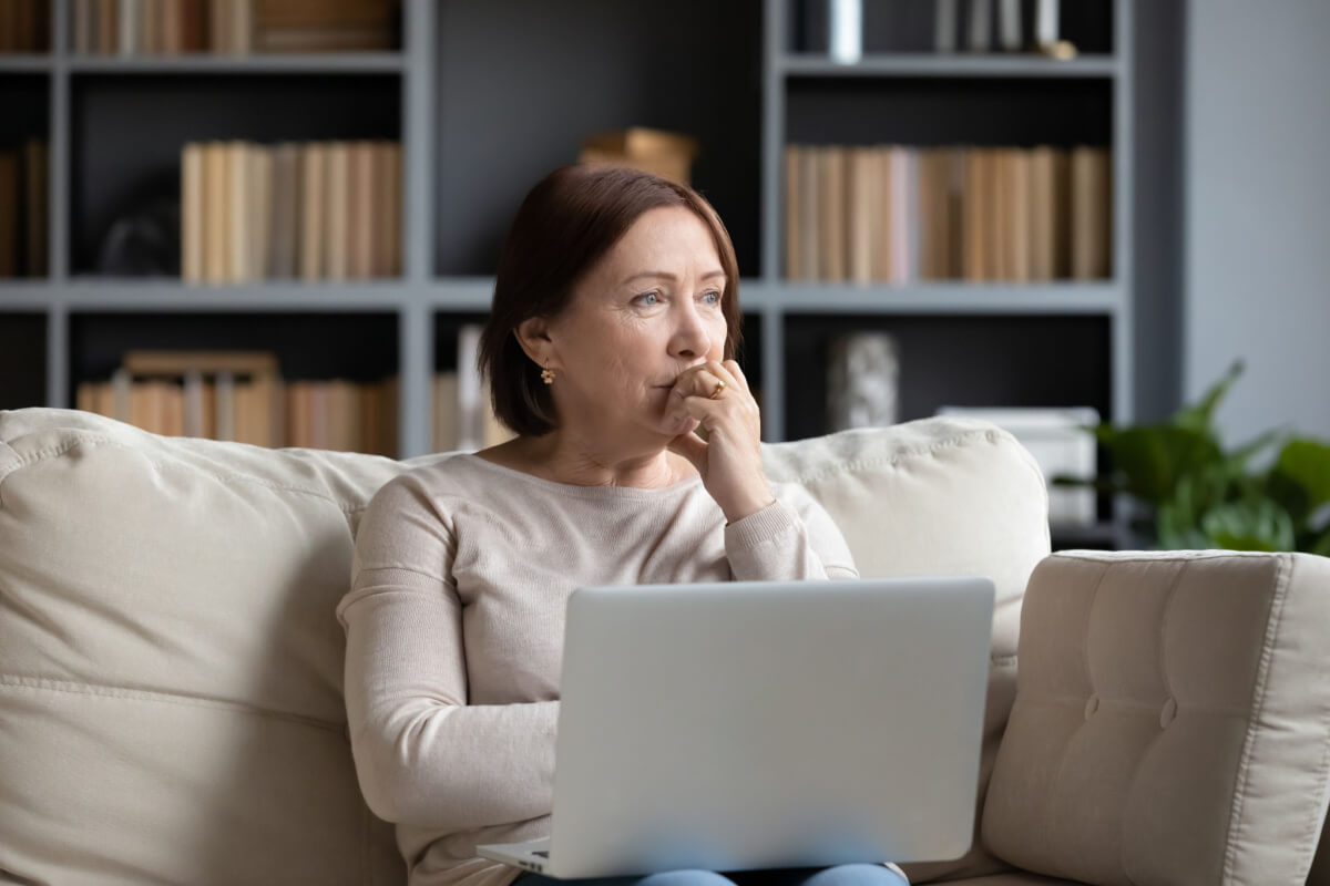 woman sitting on a couch using a laptop