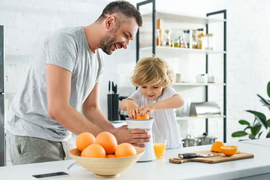 father and sun juicing citrus fruits