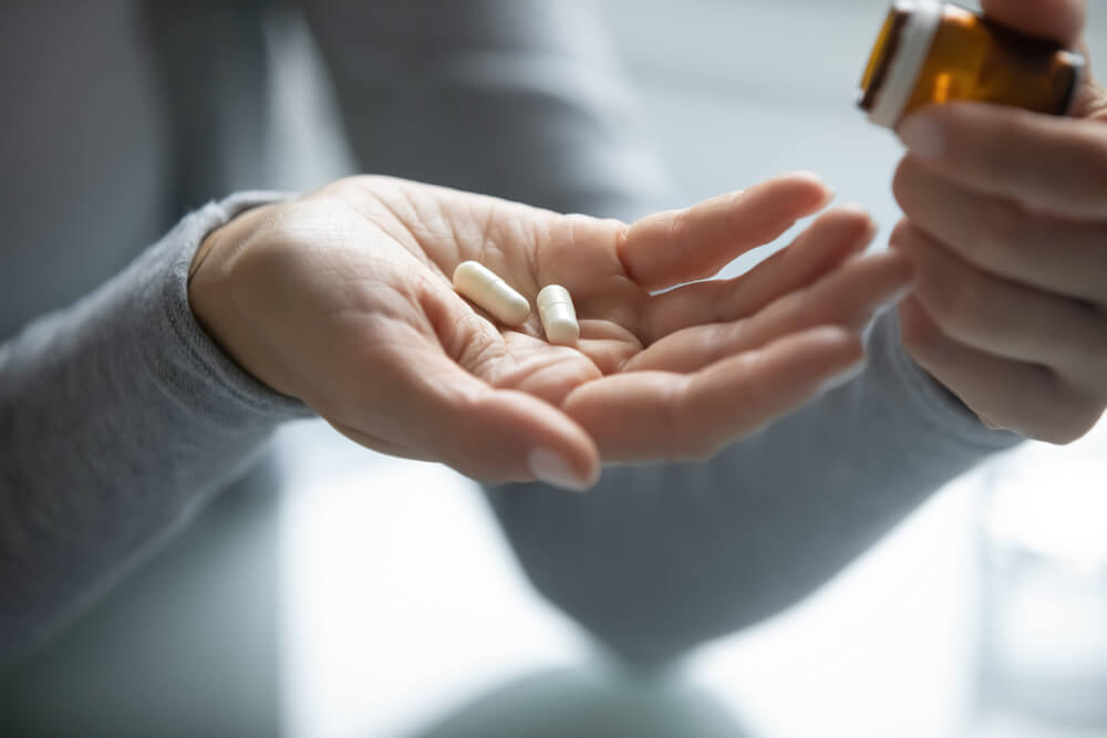 person holding two supplements