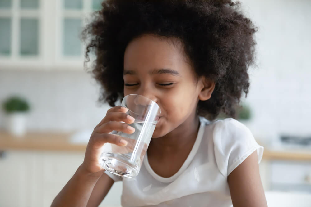 child drinking a glass of water