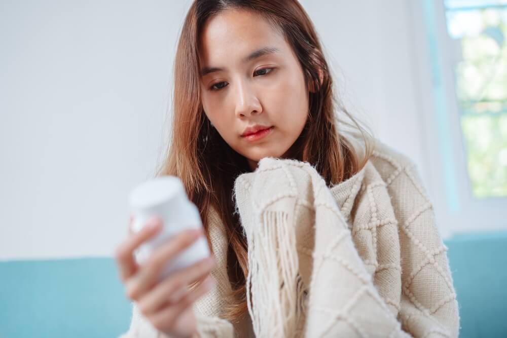 woman reading a supplement label